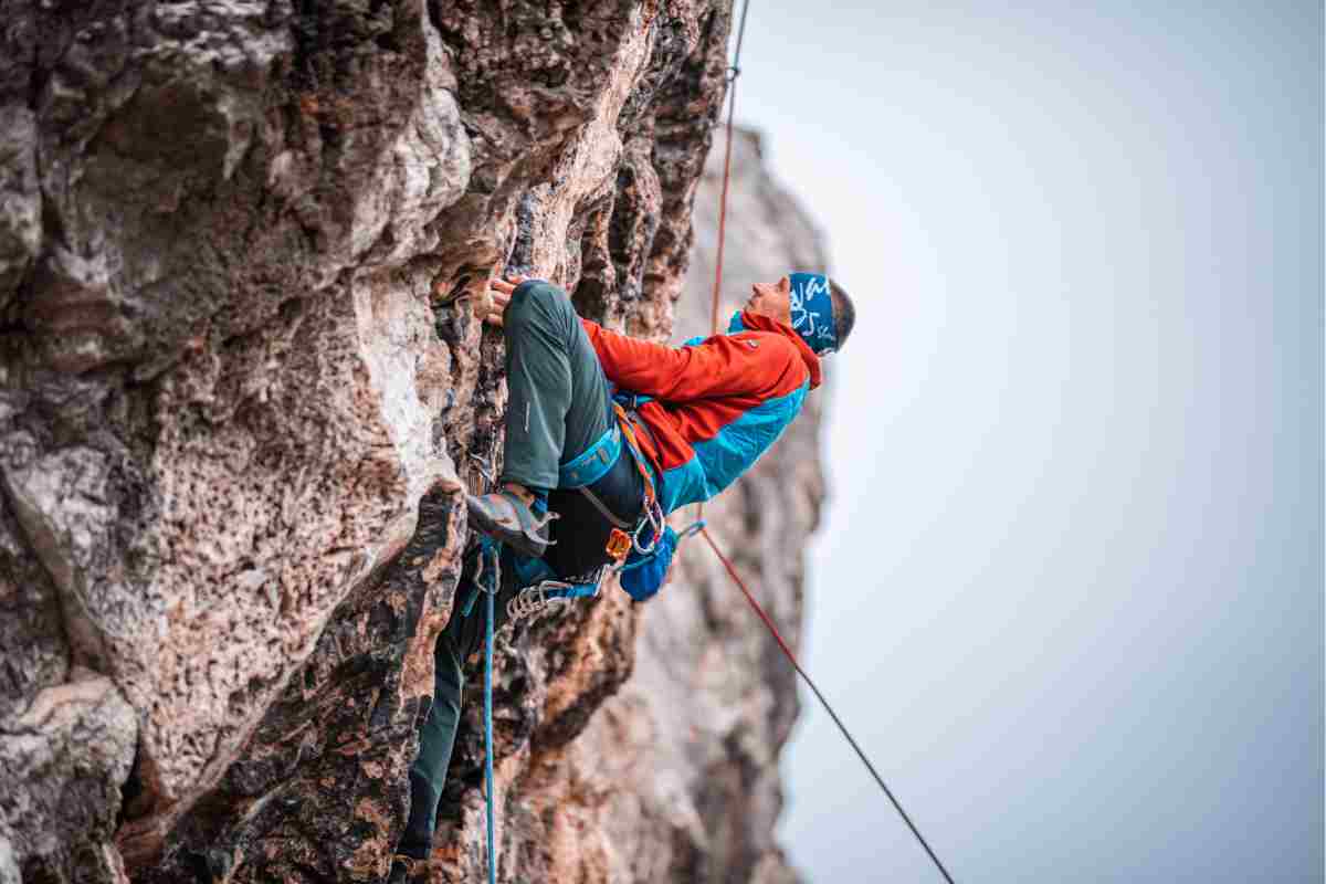 Climber sulla roccia fa arrampicata in Sardegna