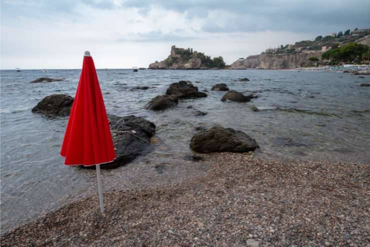 Spiaggia di Mazzarò con un ombrellone piantato tra i ciottoli