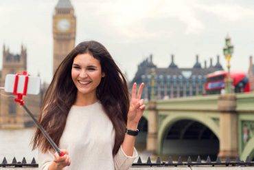 Come diventare un travel blogger, qui ragazza si scatta selfie con Londra sullo sfondo