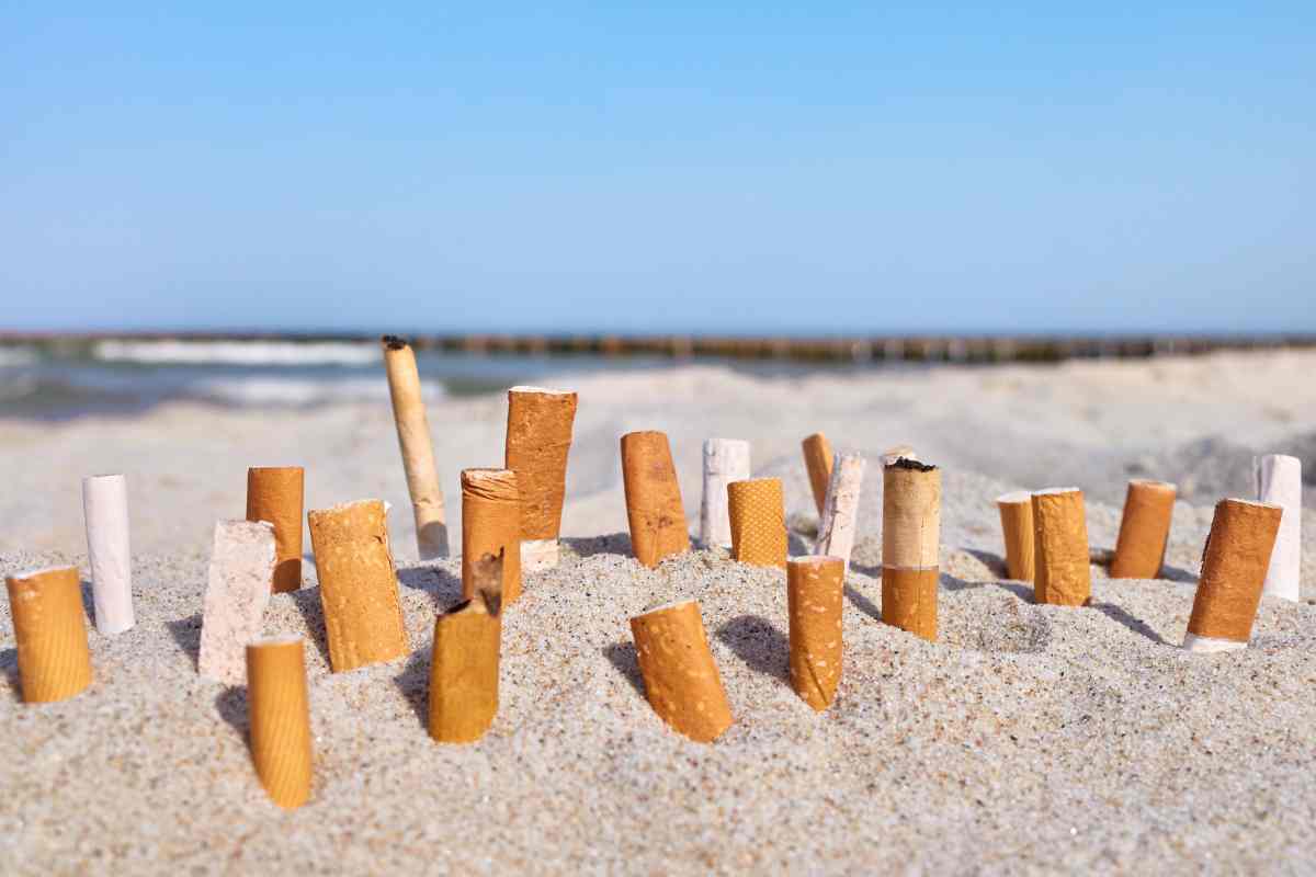 mozziconi di sigaretta sulla sabbia in una spiaggia