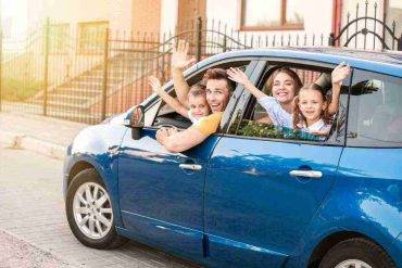 famiglia in auto blu sfondo strada