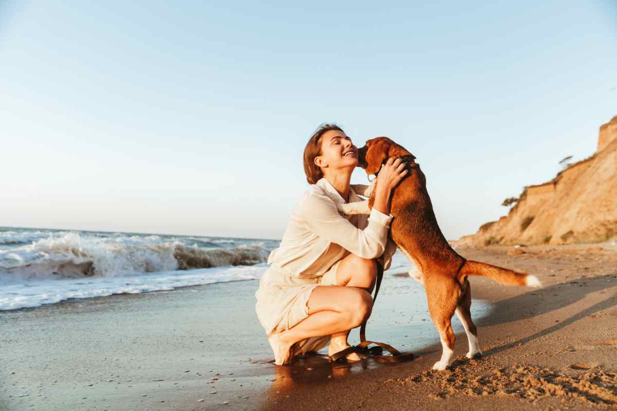 donna in spiaggia con il cane