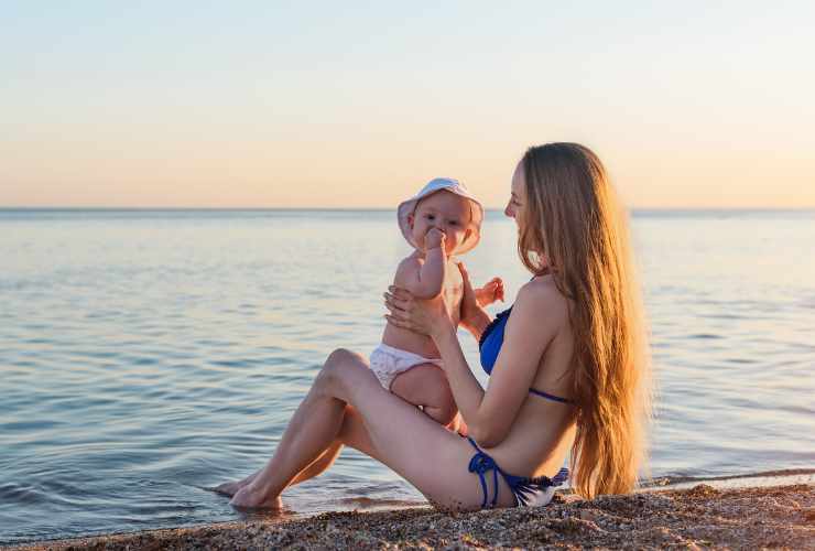 mamma e neonato in spiaggia