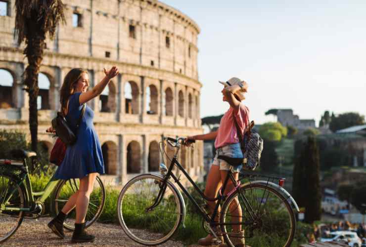 due turiste in bicicletta al Colosseo, Roma