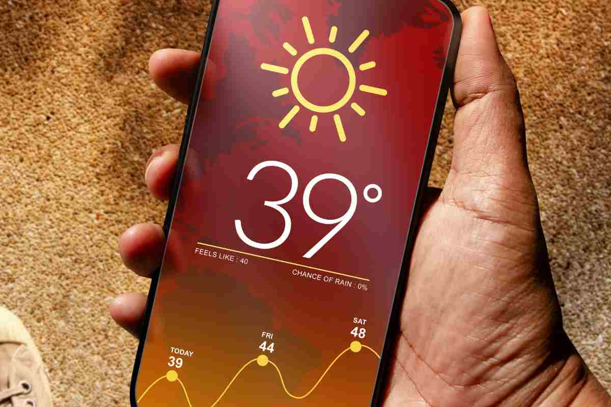 Città bollino rosso, un uomo tiene in mano uno smartphone che segna 39 gradi